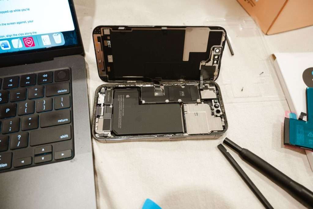 Técnico a substituir a bateria interna de um smartphone