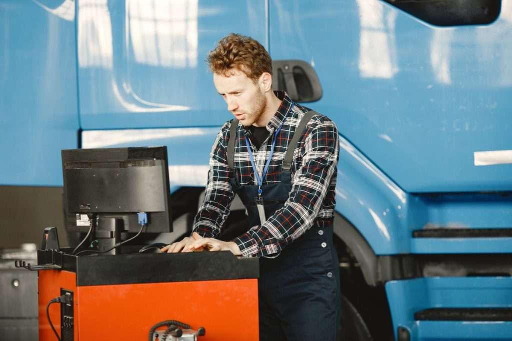 Mecânico a usar um computador numa oficina automóvel