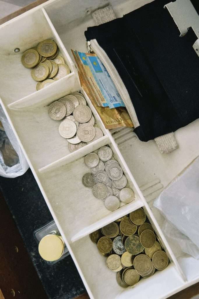 Gaveta de dinheiro com moedas e notas organizadas por compartimentos