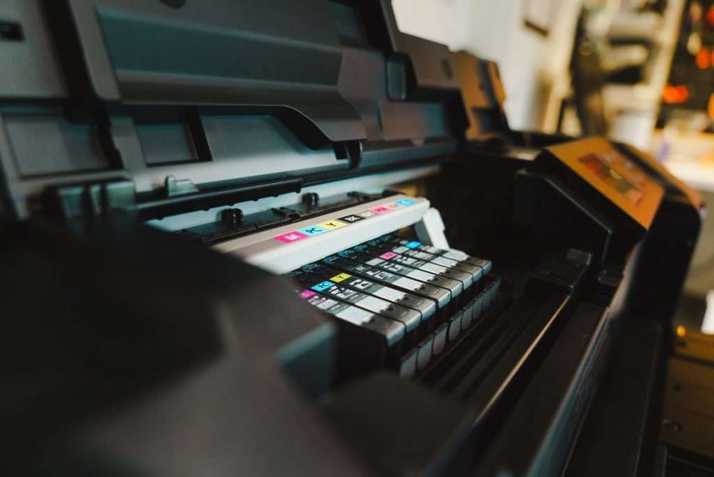 Tinteiros de várias cores dentro de uma impressora de jato de tinta num escritório