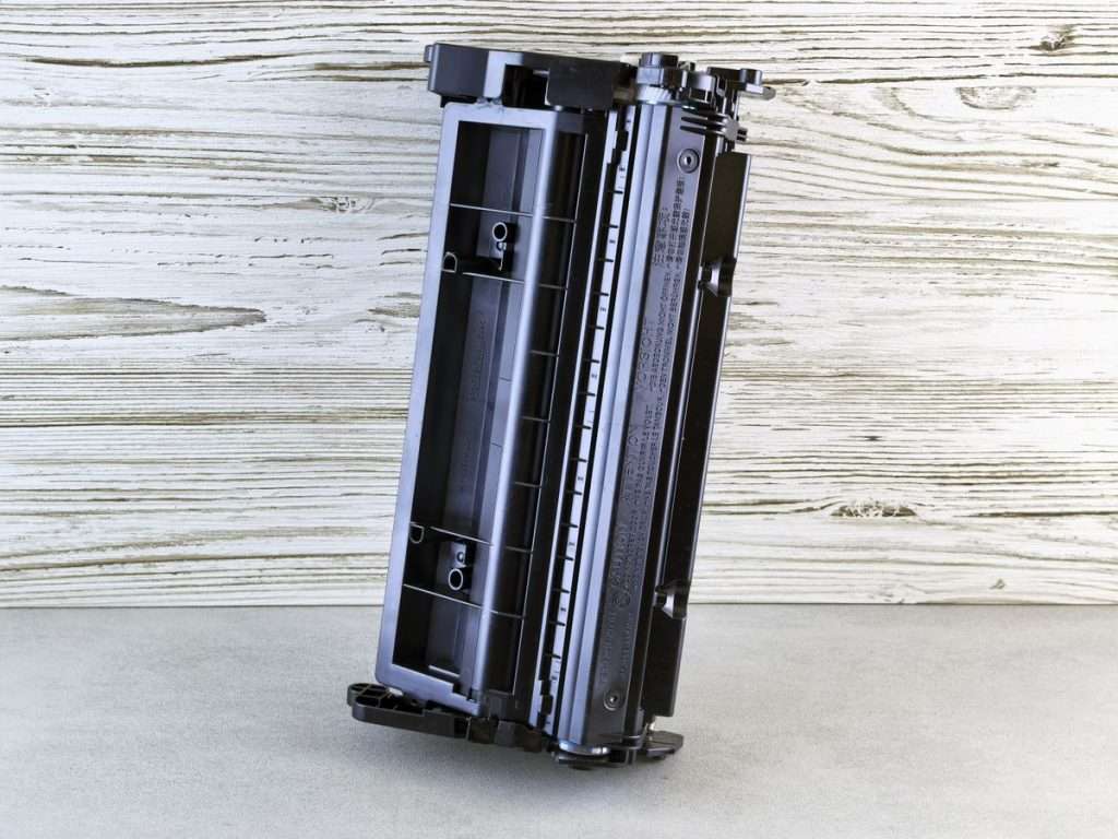 Cartucho de toner preto para impressora laser sobre um fundo de madeira clara