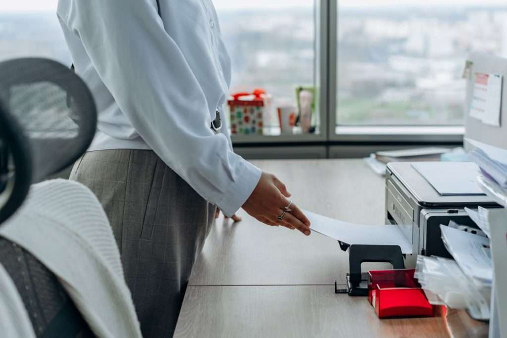 Person taking a printout from a printer in an office