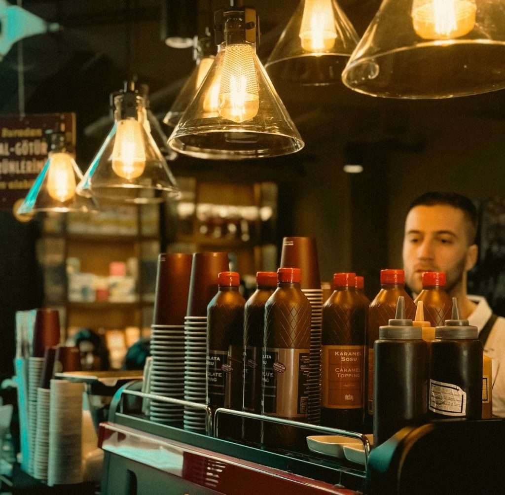 Balcão de café com máquina de espresso, copos e garrafas