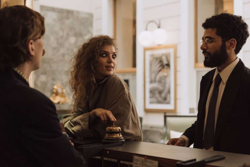 Hóspedes a falar com a rececionista na receção de um hotel