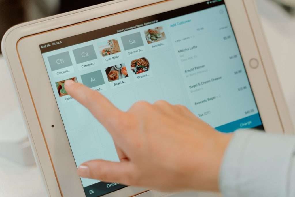 Dedo a selecionar pratos num tablet de pedidos de restaurante