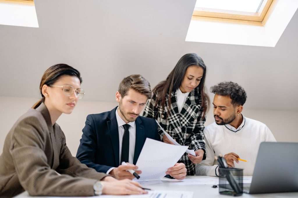 Equipa a analisar documentos numa reunião de trabalho