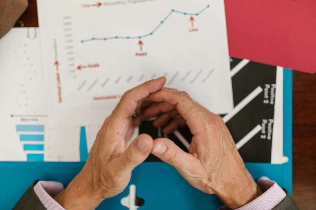 Mãos sobre gráficos e relatórios de vendas numa secretária
