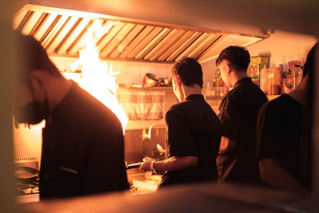 Cozinheiros a trabalhar numa cozinha profissional movimentada