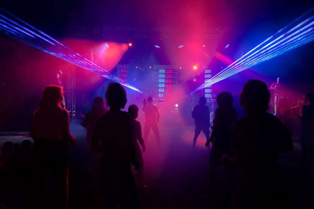 Pista de uma discoteca com luzes laser e pessoas a dançar