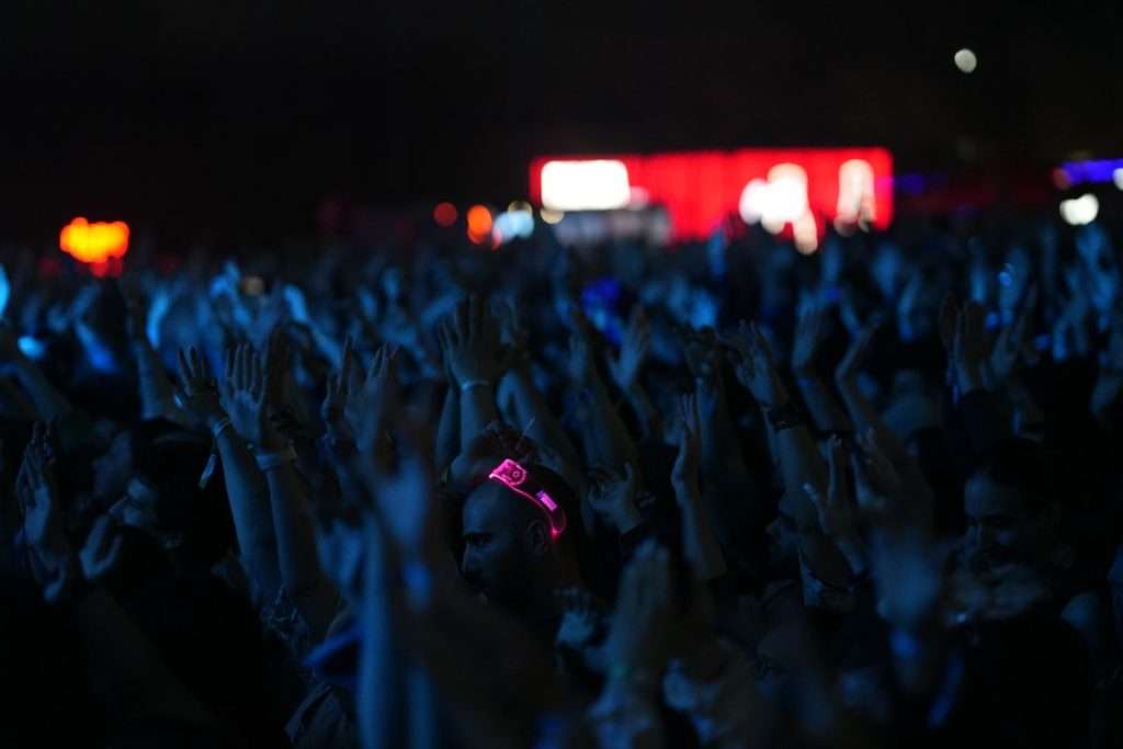 Multidão num concerto ao vivo, com luzes de palco