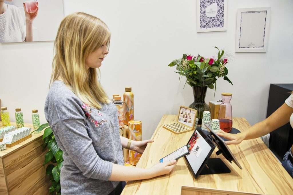 Cliente a pagar num balcão de loja, com um tablet usado como ponto de venda
